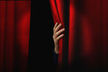 Red curtain — red curtain hand pulling back